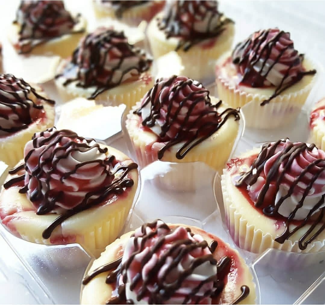 Razzy Swirl mini cheesecakes with raspberry whipped cream and chocolate drizzle